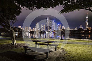 Park bench with Surfers Paradise city skyline on dusk background, Gold Coast, Australia
