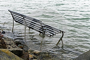 Park bench swamped by a rising sea level