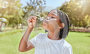 Park, child and black girl blowing bubbles enjoying fun time alone outdoors, joy and childhood development. Happy