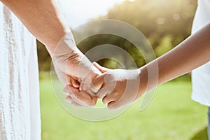 Park, family and parent holding hands with child bonding together enjoying nature and outdoors. Summer, love and hands