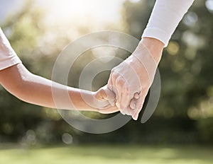 Park, family and parent holding hands with child enjoying nature, summer holiday and weekend together. Bonding, support