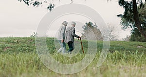 Park, friends and senior woman with walking stick to relax or quality time with hiking in environment. Conversation