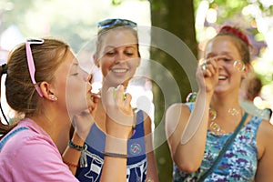 Park, friends and women with bubbles in nature on holiday, vacation and weekend outdoors. Happy, smile and people