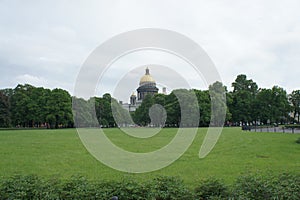 Park in front of famous Isaac cathedral in Saint Petersburg, Russia. Natural lawn showing a wide field of green grass, with trees