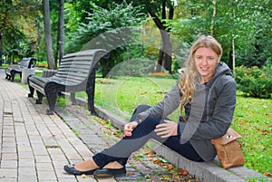 In the park, the girl sitting on the curb