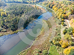 Park landscape aerial top view. trees with gold autumnal foliage growing near river