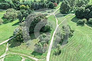 Park landscape with green trees, lawn and walking paths during summer sunny day. aerial view