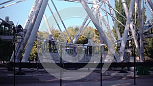 In the park, a large Ferris wheel is spinning slowly. High-altitude view wheel
