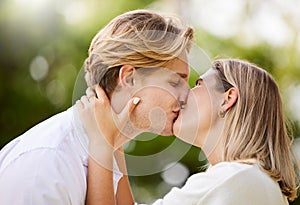 Park, love and couple kiss for romance, quality time and bonding for engagement, vacation and holiday together. Dating