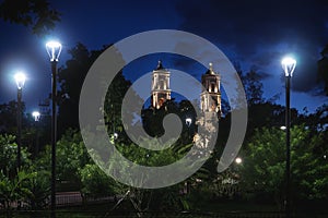 Park at main square `Francisco Canton Rosado` with towers of the church San Servacio at night in the downtown of Valladolid,