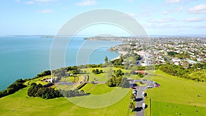 Park with memorial overlooking beautiful harbour with residential suburbs on the background. Auckland, New Zealand.