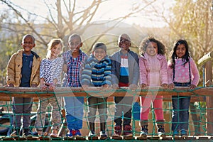 The park is our happy place. Portrait of a group of little children standing together outside.