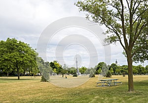 Park with a picnic bench on a sunny summer day in Toronto with a view of the CN tower