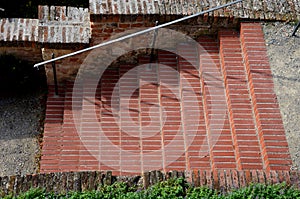 Park staircase on the terrace of an Italian garden. the stairs are made of red bricks glued to cement. forged metal railing on the