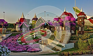 In the park there is a colorful flowerbed in the shape of a clock