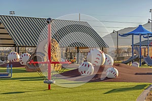 Park with a variety of playground equipment and structures viewed on a sunny day