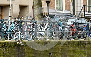 Parked against a red brick wall, a third bicycle securely locked in front