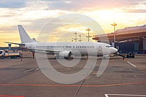 Parked aircraft on an airport through the gate window, evening light sunset dawn