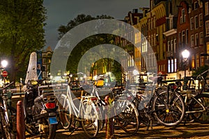 Parked Bicycles and Scooter in Amsterdam at Night