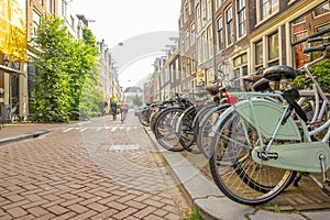 Parked Bikes and a Few Cyclists on an Amsterdam Street
