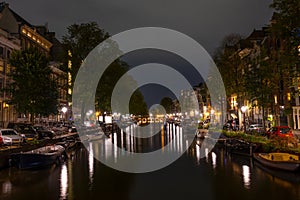 Parked Boats and Cars on Amsterdam Canal at Night