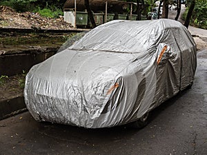 Parked car with protective gray rain cover