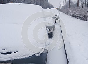 Parked cars covered with fresh white snow