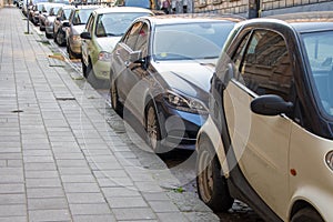 Parked cars in a European city along the cobblestone pavement, Deserted street in the city