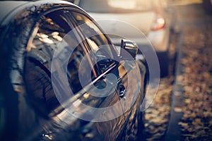 Parked cars. Reflection of the building in the shiny surface of the car