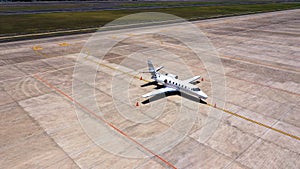 Parked expensive private airplane on concrete ground of airport, aerial. Small business jet parked on the runaway