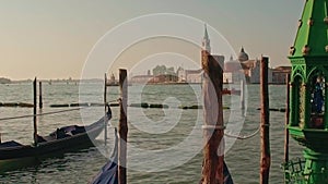 Parked gondolas on Piazza San Marco and The Doge's Palace embankment with the bell tower of the Saint Giorgio Maggiore