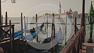 Parked gondolas on Piazza San Marco and The Doge's Palace embankment with the bell tower of the Saint Giorgio Maggiore