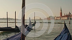 Parked gondolas on Piazza San Marco and The Doge's Palace embankment with the bell tower of the Saint Giorgio Maggiore