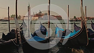 Parked gondolas on Piazza San Marco and The Doge's Palace embankment with the bell tower of the Saint Giorgio Maggiore