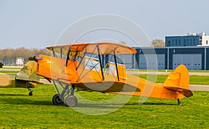 Parked orange stunt airplane at the airport, acrobatic flying and extreme hobbies