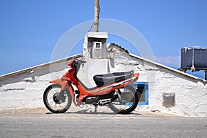 Parked scooter in front of old stone house