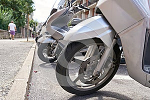 parked scooters on a street of Riva del Garda in Italy