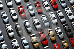 Parked toy cars on a black background like a car parking lot