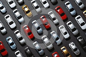 Parked toy cars on a black background like a car parking lot