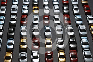 Parked toy cars on a black background like a car parking lot