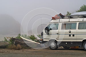 A parked van loaded with surfboards and gear parked at the beach in Tofino in British Columbia