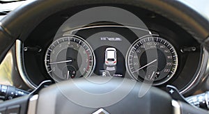 Parking Assistant Icon Between Speedometer And Tachometer On Car Dashboard