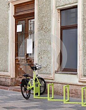 Parking for bicycles and electric scooters in front of an old typical building. The photo.
