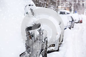 Parking cars after snowfall. Automobiles covered with snow. Winter concept