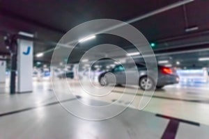 Parking garage blurred. Empty road asphalt background in soft focus. Car lot parking space in underground city garage. Modern