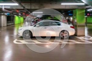 Parking garage blurred. Empty road asphalt background in soft focus. Car lot parking space in underground city garage. Modern