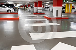 Parking garage - interior shot of multi-story car park, underground parking with cars. Parking garage underground