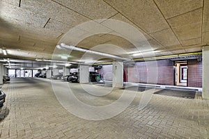 a parking garage with parked cars and a brick wall