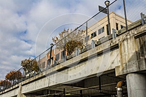 Parking garage under street with view to fencing, barriers, and buildings above