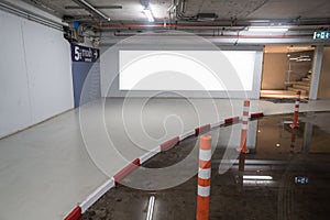 Parking garage underground interior with blank billboard.Empty space car park interior at afternoon